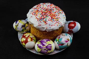 Festive cake and beautiful eggs for Holy Easter on a black background.