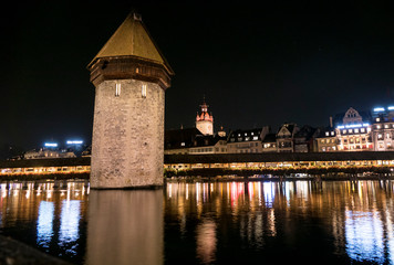 Fototapeta premium Illuminated Lucerne and Chapel Bridge reflect on the river
