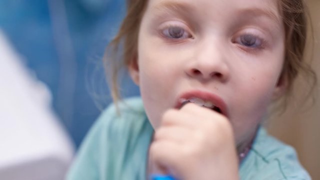 taking care of your teeth, a little girl squeezes toothpaste on the brush.