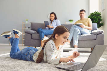 Happy family watching together video online in a laptop while sitting comfortably at home.