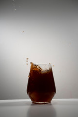 coke splash with ice in a drinking glass