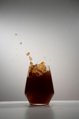 coke splash with ice in a drinking glass