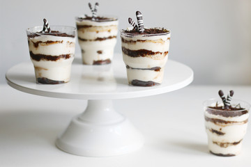 Classic tiramisu in a glass and light background. portioned tiramisu on light background.