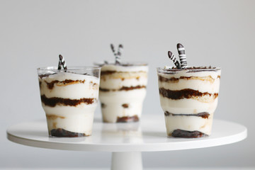 Classic tiramisu in a glass and light background. portioned tiramisu on light background.