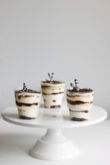 Classic tiramisu in a glass and light background. portioned tiramisu on light background.