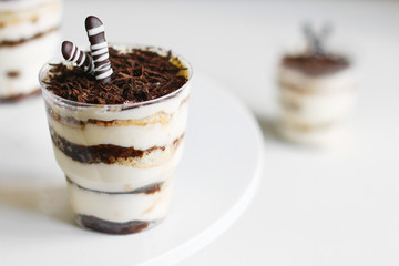 Classic tiramisu dessert in a glass and cup of coffee on light background. dessert with copy space closeup