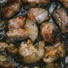 Sliced pieces of meat with fat are cooked in a skillet. Roasted meat for lunch or dinner. Cooking at home or in a restaurant.