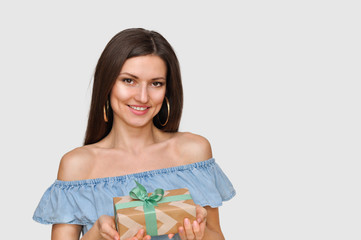 Beautiful smiling sexy woman holds beautiful a gift box in her hands.