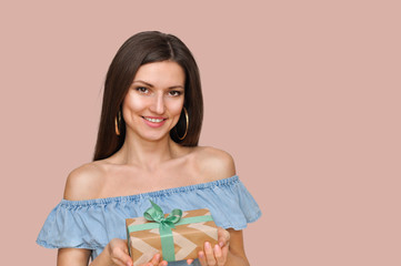 Beautiful smiling sexy woman holds beautiful a gift box in her hands.