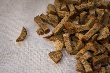 crackers are scattered on a cotton cloth for salad beer snacks with garlic and cereals from rye bread with seeds