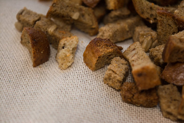 crackers are scattered on a cotton cloth for salad beer snacks with garlic and cereals from rye bread with seeds