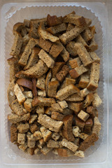 crackers are in a plastic container from the store for salad beer snacks with garlic and cereals from rye bread with seeds