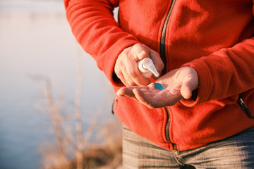 man using alcohol antiseptic gel in sanitizer bottle for frequently cleaning hands and prevent...