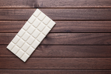 White chocolate bar on wooden background with copy space, flat lay