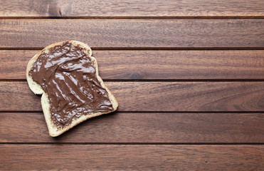 Toast with chocolate on wooden background with copy space, flat lay