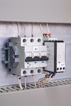 Modular circuit breaker, phase control relay and a stop that locks them on a rail in the electrical Cabinet. Wires are connected to the switch and relay. The wires are marked.