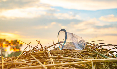 Foam boxes, plastic cluttered on a haystack on the field.Plastic waste on the field is not allowed to be thrown away.Waste plastic pollution main concepts.It is difficult to decompose.
