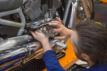 Man repairing one of the mechanisms of a motorcycle.