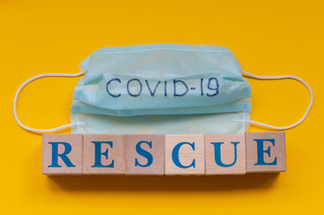 Medical mask with the inscription COVID-19 and cubes with the inscription rescue. Coronavirus...