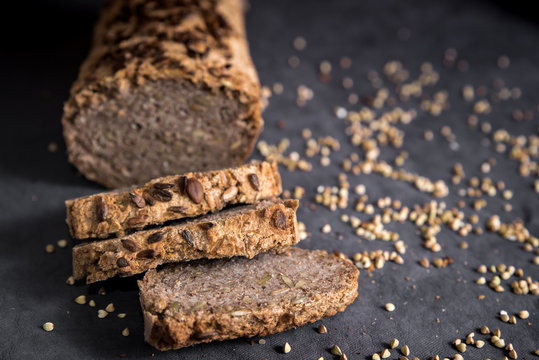 Home Made Vegan Buckwheat Bread On Dark Background With Grains. Freshly Baked Gluten Free Bread, Baked Goods Cut In Slices. Gluten Intolerance