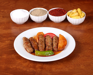very nice izmir patties with potato tomatoes, peppers and white spices on a white plate with fragrant turkish spices