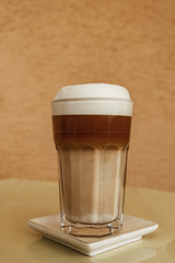 Milkshake or coffee served in a glass with lid