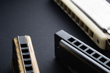 old two diatonic and chromatic harmonica on a dark background. Horizontal. copy space