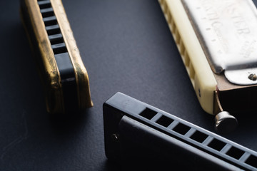 old two diatonic and chromatic harmonica on a dark background. Horizontal. copy space