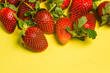 A closeup of fresh strawberries. Top view of fresh and juicy strawberries on a yellow background.