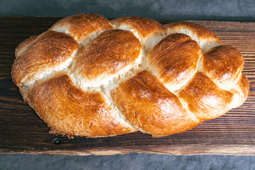 Homemade Jewish traditional challah bread on rustic wooden table. Top view of fresh baked challah