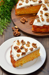 Piece of carrot cake with icing decorated walnut