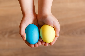 Fototapeta na wymiar children's hands hold colored eggs
