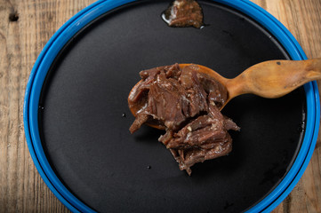 Beef meat on a spoon in a tourist bowl. Macro photo of a beef stew.