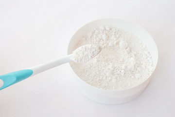 close-up of tooth powder in a jar and a toothbrush on a white background. text space, top view, layout