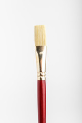 One professional artist paintbrush displayed vertically isolated on a white studio paper, photographed with soft focus
