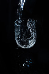 glass with water splashes on a black background