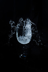 glass with water splashes on a black background