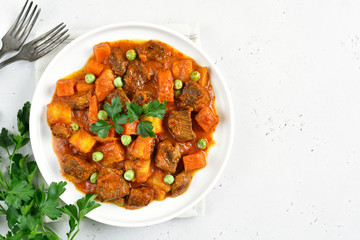 Beef stew with potatoes and carrots in tomato sauce