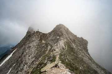 foggy mountain ridge with tiny human