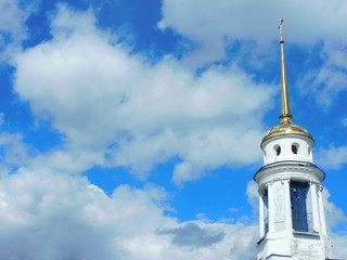 
Religion: church bell tower on a background of blue sky with clouds.