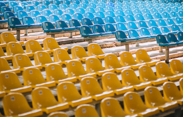 Benches, chairs, rows in a large stadium and theater with numbering of blue, yellow and blue. Ukrainian flag. Photography, concept.