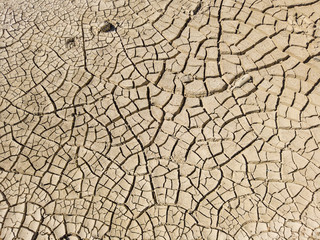 Overhead top view of dry arid soil with cracks during intense heat. Lack of water on agriculture field. Concept of global warming.