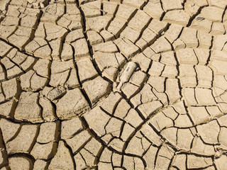 Overhead top view of dry arid soil with cracks during intense heat. Lack of water on agriculture field. Concept of global warming.
