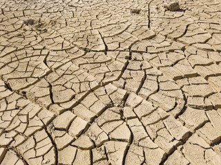 Overhead top view of dry arid soil with cracks during intense heat. Lack of water on agriculture field. Concept of global warming.