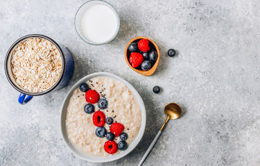 Breakfast oatmeal porridge with fresh berries and almond milk. Healthy vegan food concept. Top view. Copy space. Flat lay