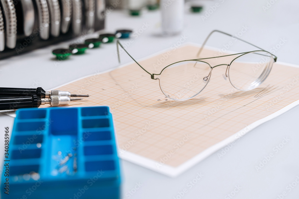 Poster optician repairing equipment and fixing eyeglasses. broken glasses laying on table in optician works