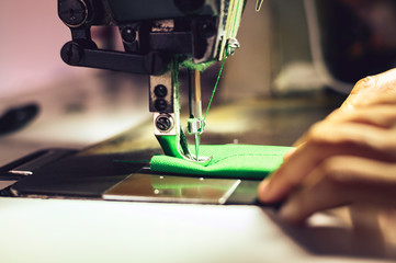 Green work sewing process The woman's hand behind her tailoring