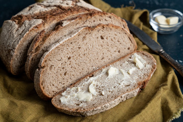 Homemade reshly baked country bread made from wheat and whole grain flour sliced with butter