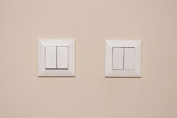 4 lamp switches close-up. They have a white color and are dirty and used. Indoor.