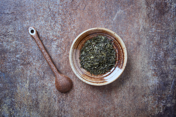 Dried Green Tea ( sencha) Leaves on rustic stone Background. Top view. Copy space.